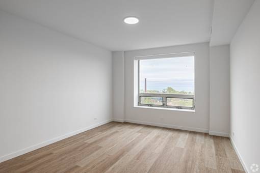 A room with a large window and wooden flooring.