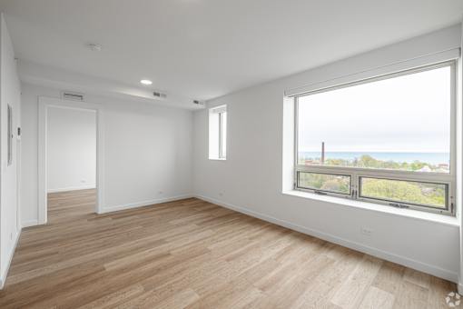 A room with a large window overlooking the ocean.