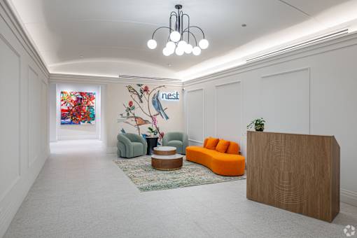 A reception area with a wooden reception desk and a mural on the wall.