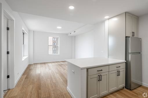A kitchen with wooden floors and white walls.