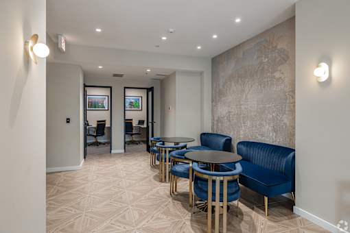 A room with blue chairs and a patterned wallpaper.