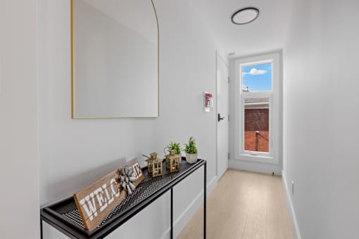 A hallway with a black railing and a wooden sign that says "welcome".