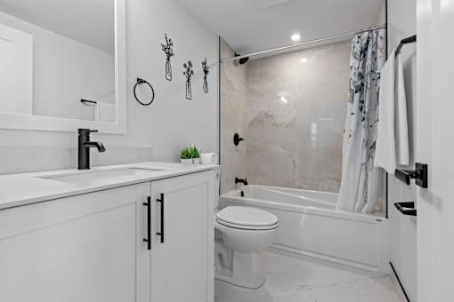 A white bathroom with a toilet, sink, and bathtub.