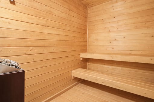 A wooden sauna with benches and a table.