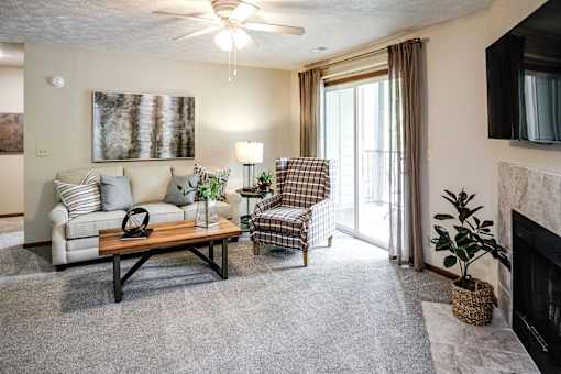 A living room with a couch, chair, and a fireplace. at The Pointe, LaVista, 68128