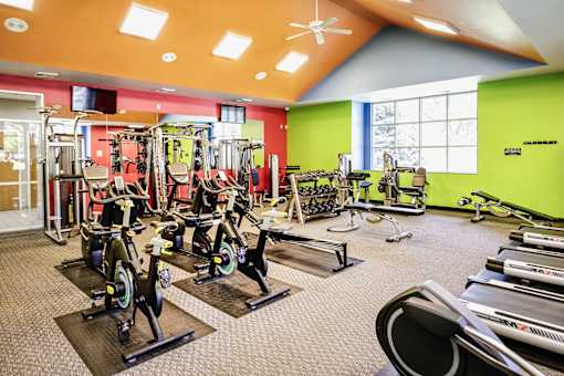 A gym with a variety of exercise equipment including treadmills, stationary bikes, and weight machines. at The Pointe, Nebraska, 68128