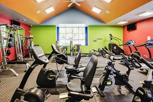 A gym with a variety of exercise equipment including treadmills, stationary bikes, and weight machines. at The Pointe, LaVista, NE, 68128