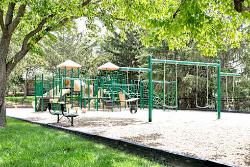 A playground with a green swing set and a yellow slide. at The Pointe, Nebraska, 68128