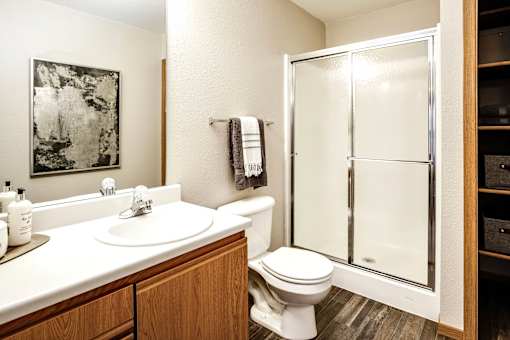 A bathroom with a toilet, sink, and shower. at Tranquility Pointe, Omaha, NE