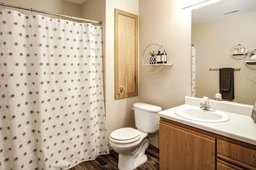 A white toilet sits next to a sink in a bathroom. at Tranquility Pointe, Omaha