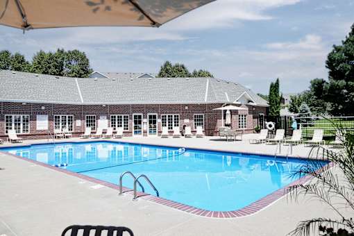 A large swimming pool in front of a building with a covered seating area. at Tranquility Pointe, Nebraska, 68164