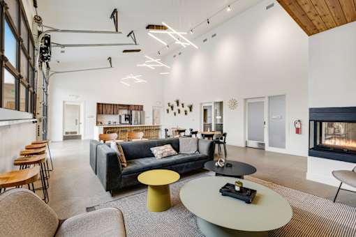 A modern living room with a fireplace and a grey sofa.