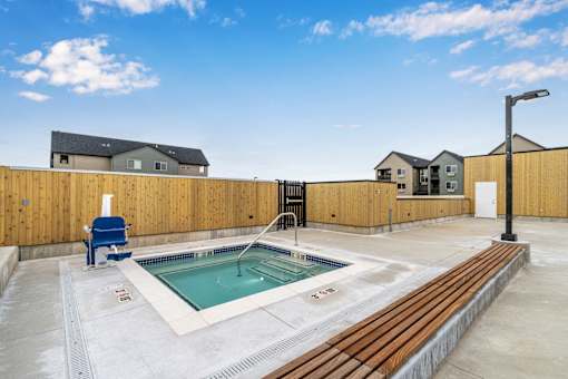 A small pool with a blue chair and a wooden fence.
