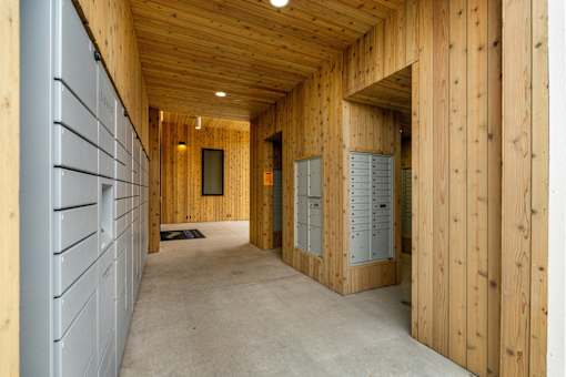 A long hallway with wooden walls and a concrete floor.