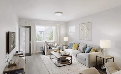 A modern living room with a grey sofa, a wooden coffee table, and a flat-screen TV mounted on the wall.