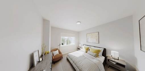 A bedroom with a large bed and a brown chair.