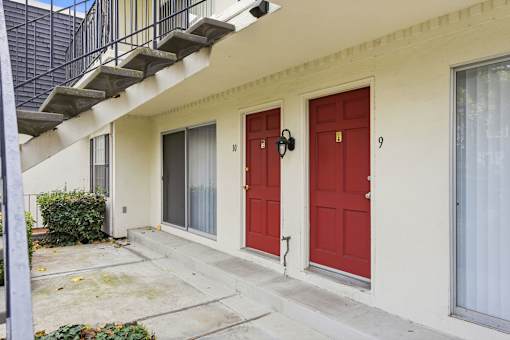 A white house with red doors numbered 9 and 10.
