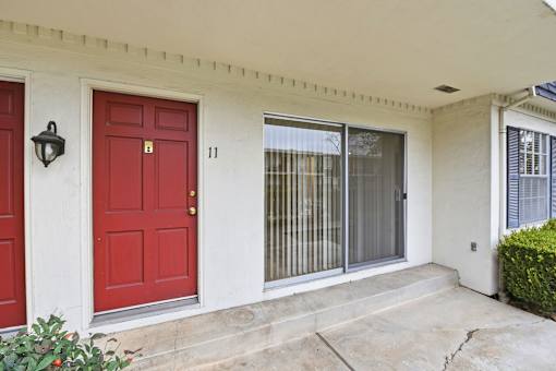 A red door with a black lantern above it is on the left.