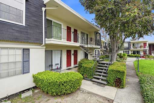 A house with a red door and a green lawn.