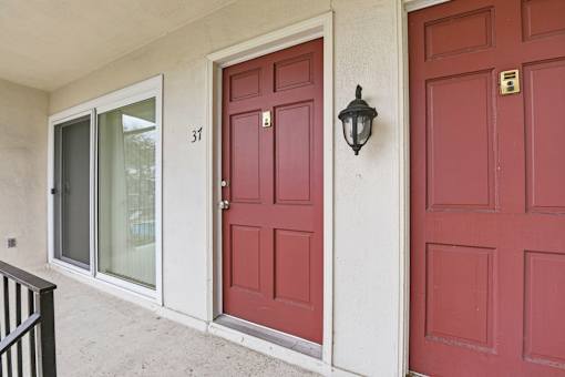 A red door with a black lantern on the wall.