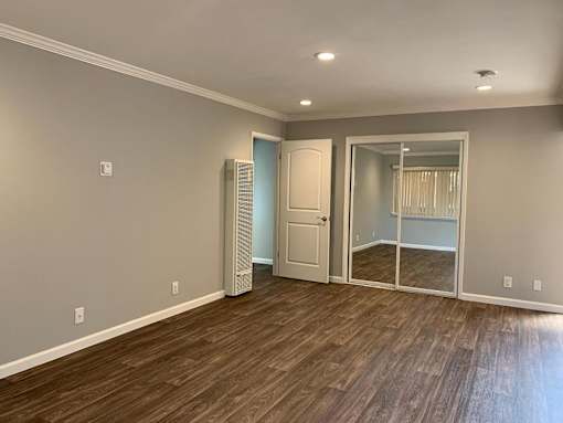 A room with wooden flooring and a white door.
