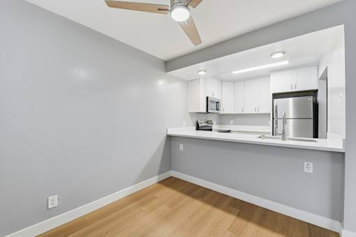 A kitchen with a refrigerator, microwave, and oven.