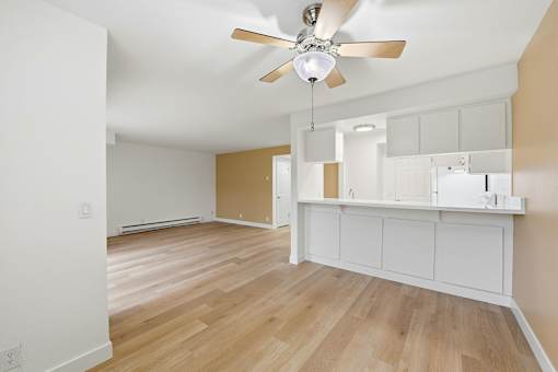 A room with a ceiling fan and wooden flooring.
