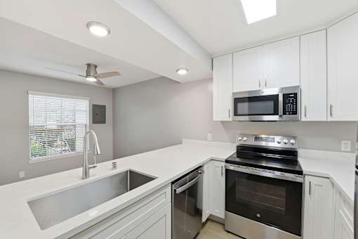 A modern kitchen with a stainless steel sink and oven.