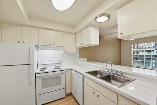 A kitchen with white appliances and cabinets.