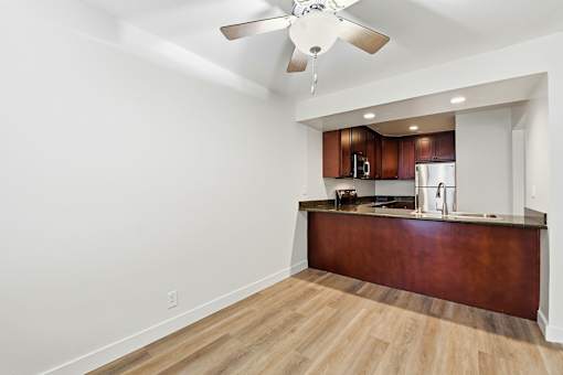 A kitchen with a wooden counter and a ceiling fan.