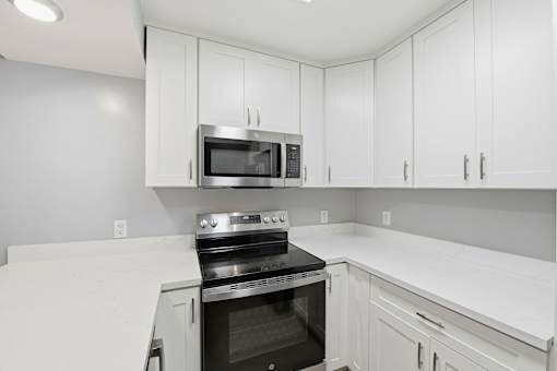 A kitchen with white cabinets and a black oven.