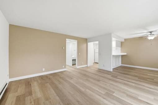 A room with wooden flooring and white walls.