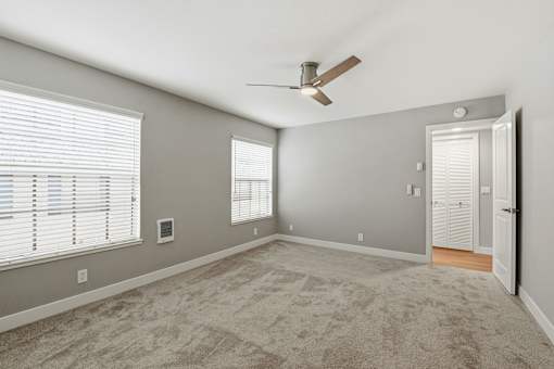 A room with a ceiling fan and a door.