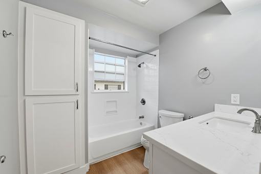 A white bathroom with a toilet, sink, and bathtub.