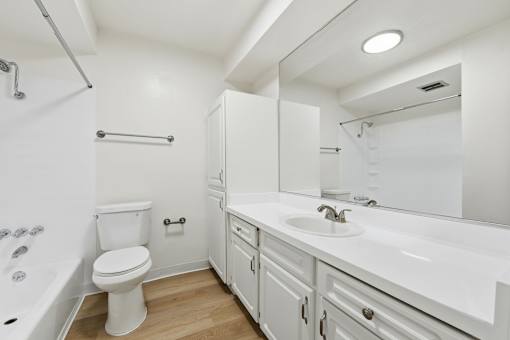 A white bathroom with a toilet, sink, and bathtub.