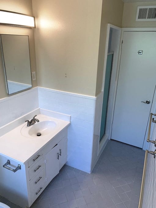 an empty bathroom with a sink and a shower