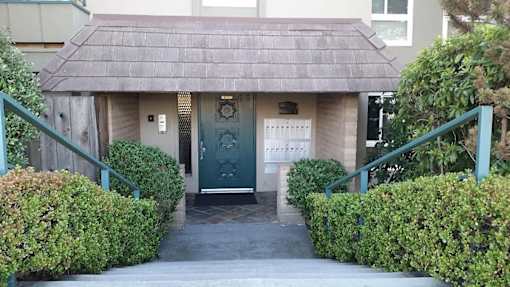 A small building with a green door and a sign on it.