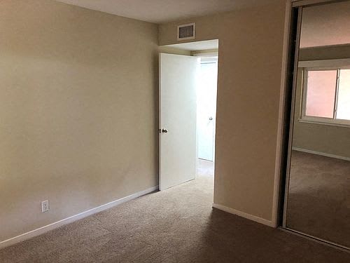 an empty room with a door and a mirror