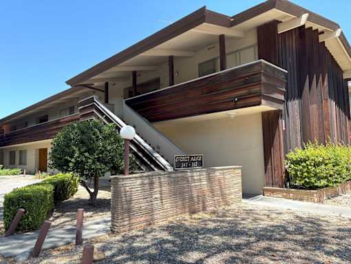 A modern house with a wooden exterior and a sign that reads "1707 ALLEN".