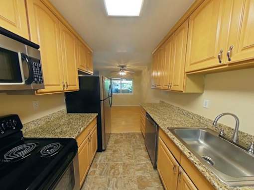 A kitchen with wooden cabinets and granite countertops.