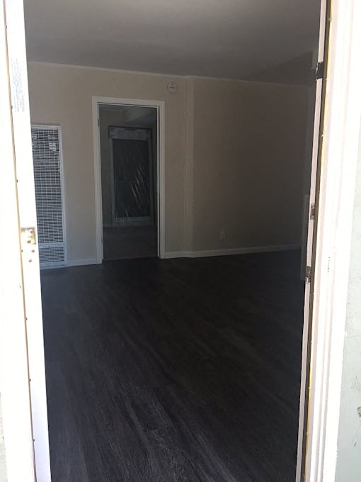 A room with a dark floor and white walls.