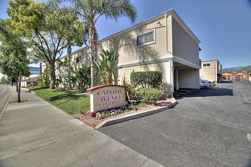A street view of a residential area with a sign that reads