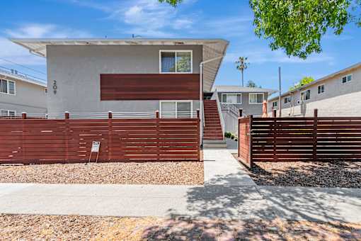 A modern house with a brown fence and a white wall.