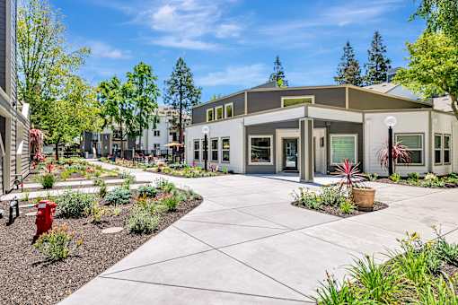 A building with a grey roof and a red fire hydrant in front of it.