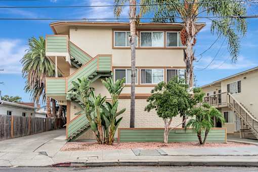 A two-story house with a green staircase on the side.