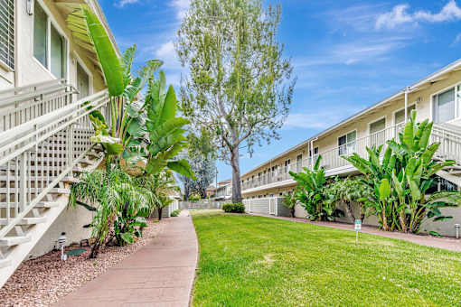 A sunny day at a residential area with apartment buildings and greenery.