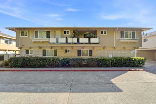 A two-story apartment building with a balcony on the second floor.
