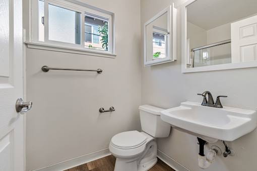 A white toilet sits next to a white sink in a bathroom.