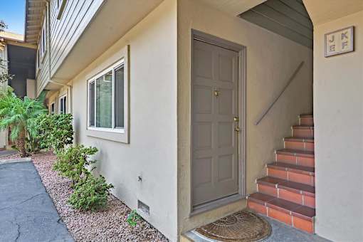 A house with a grey door and a staircase leading to the entrance.