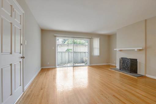 A room with a fireplace and wooden floors.